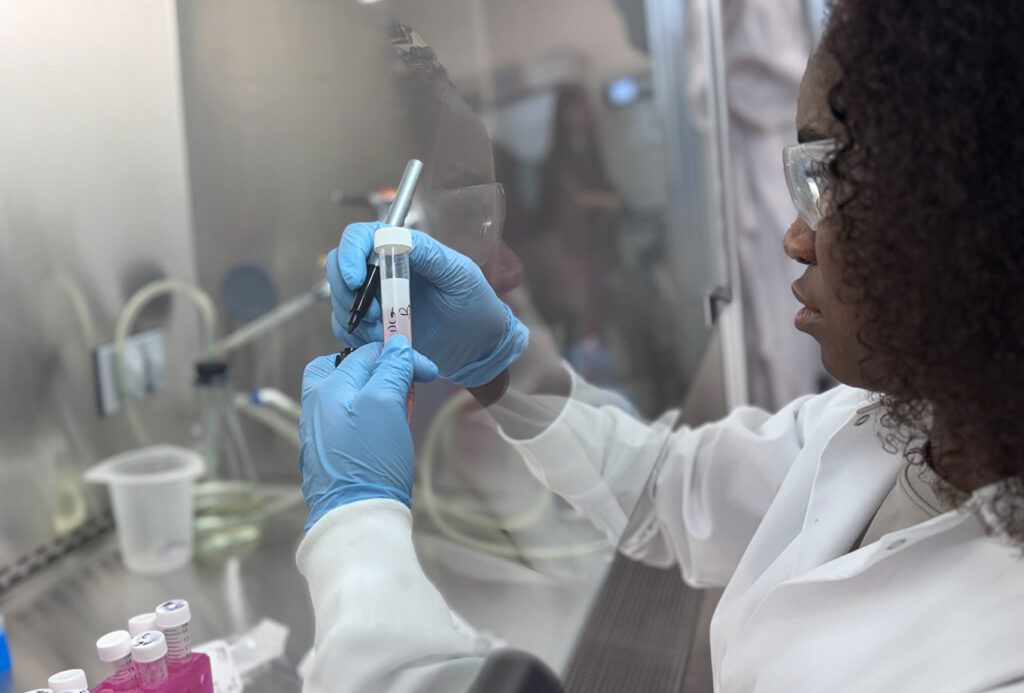 SMCC Student in lab in white coat.