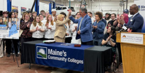 Gov. Mills celebrates with EMCC students and staff on signing supplemental budget.